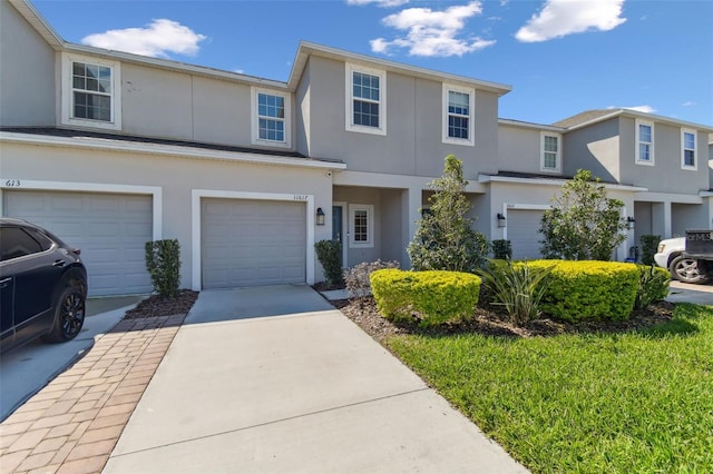 view of property with driveway, an attached garage, and stucco siding