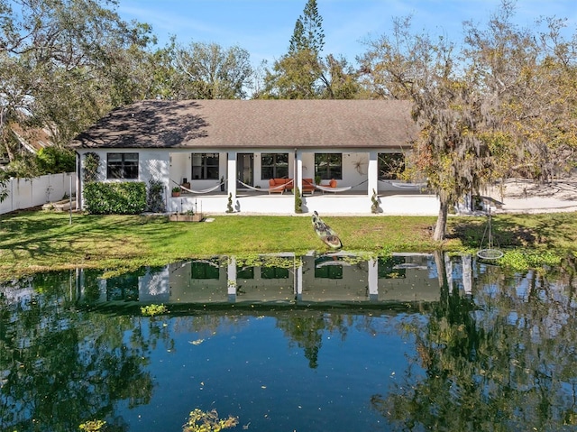 rear view of property featuring a patio, a lawn, and fence