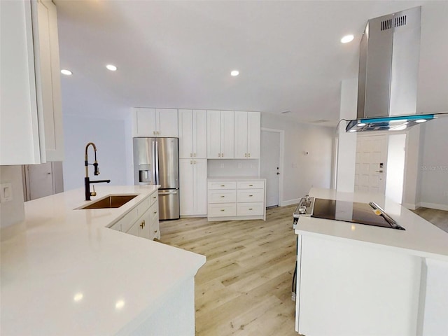 kitchen with a peninsula, a sink, light wood-style floors, stainless steel refrigerator with ice dispenser, and range hood