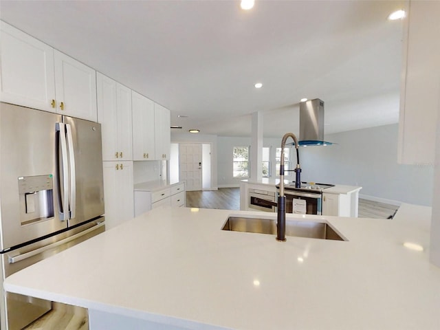 kitchen with light countertops, light wood finished floors, stainless steel fridge with ice dispenser, and white cabinetry