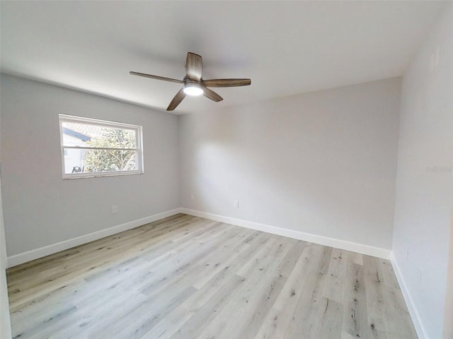 spare room featuring light wood-style floors, baseboards, and a ceiling fan