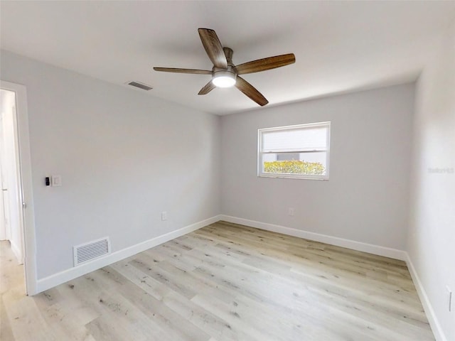 empty room with light wood-style flooring, a ceiling fan, visible vents, and baseboards