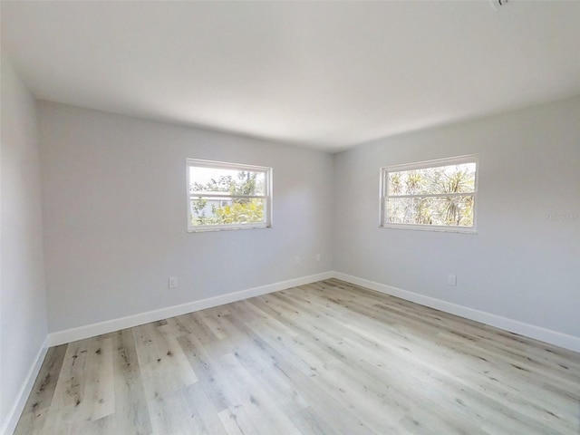 empty room featuring light wood-type flooring and baseboards