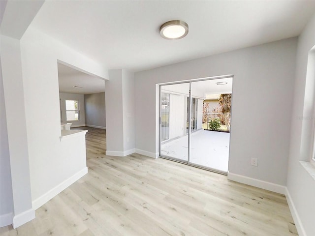 empty room with light wood finished floors and baseboards