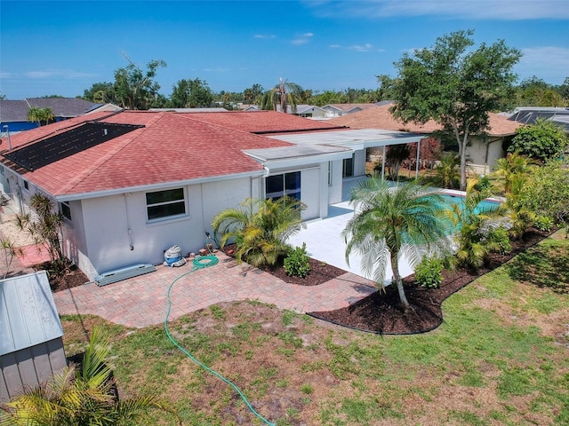 back of property featuring a shingled roof, a patio area, and stucco siding