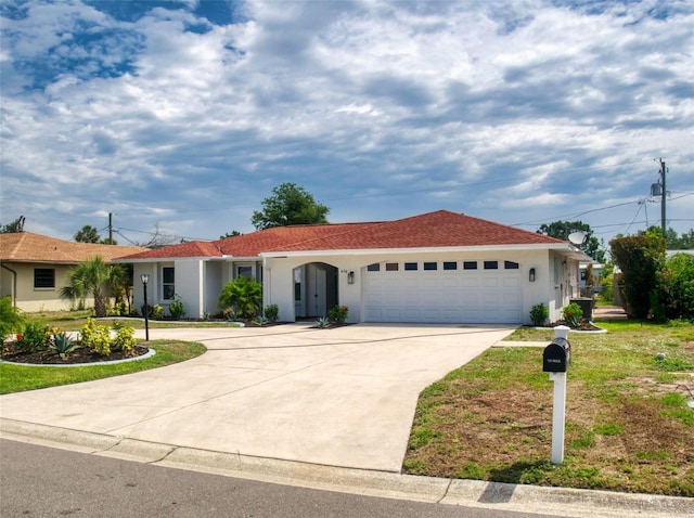 single story home with a garage, concrete driveway, and stucco siding