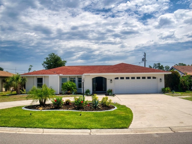 view of front of home with a front yard, driveway, an attached garage, and stucco siding