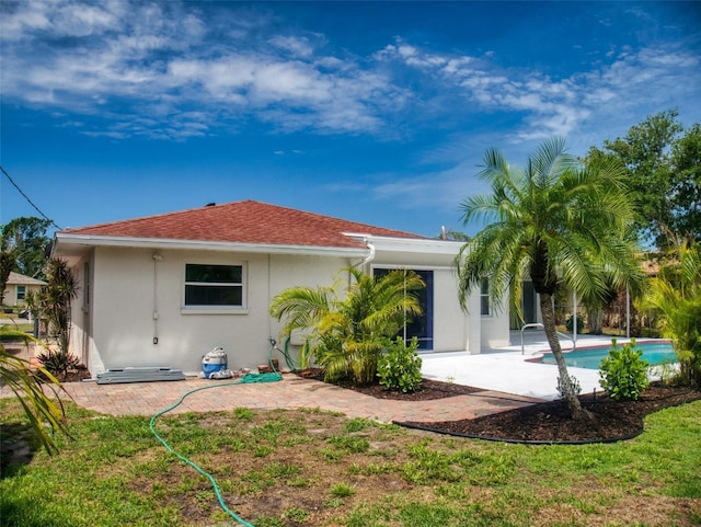 back of house with an outdoor pool, a patio area, and stucco siding