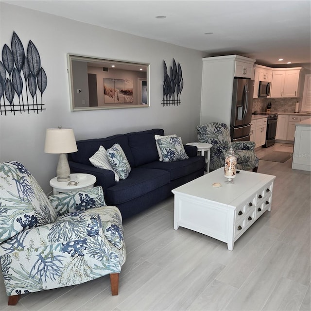 living area with light wood finished floors and recessed lighting