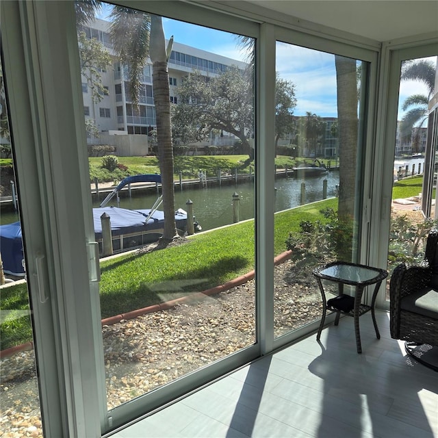 sunroom featuring a water view