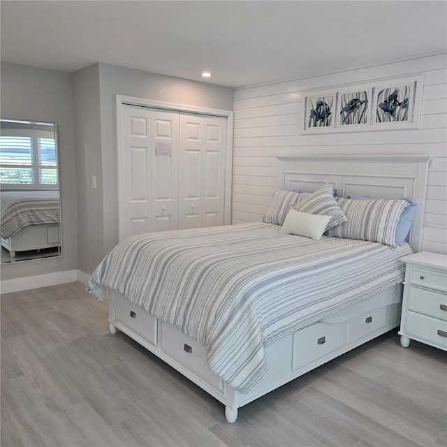 bedroom featuring a closet, recessed lighting, wood finished floors, and baseboards