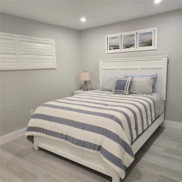 bedroom with recessed lighting, wood finished floors, and baseboards