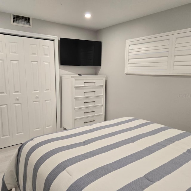 bedroom with a closet, visible vents, and recessed lighting