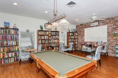 playroom with billiards, visible vents, brick wall, ceiling fan, and wood finished floors