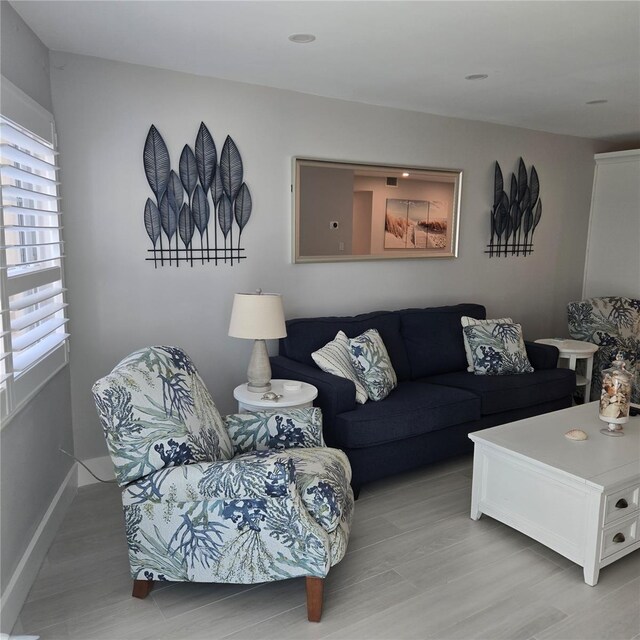 living area with light wood-type flooring and baseboards
