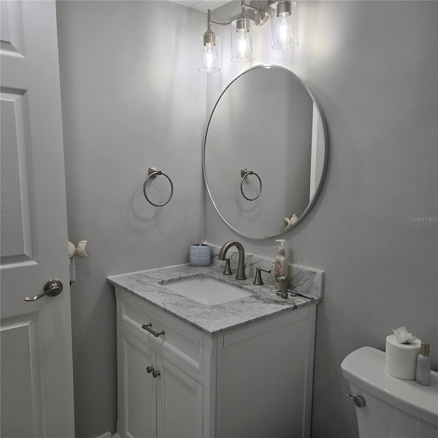 half bathroom featuring vanity and toilet