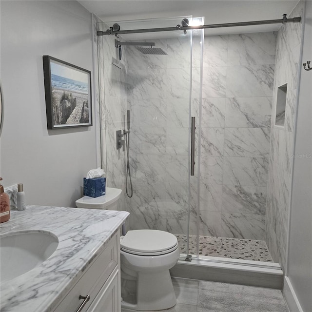 full bathroom featuring a marble finish shower, toilet, and vanity