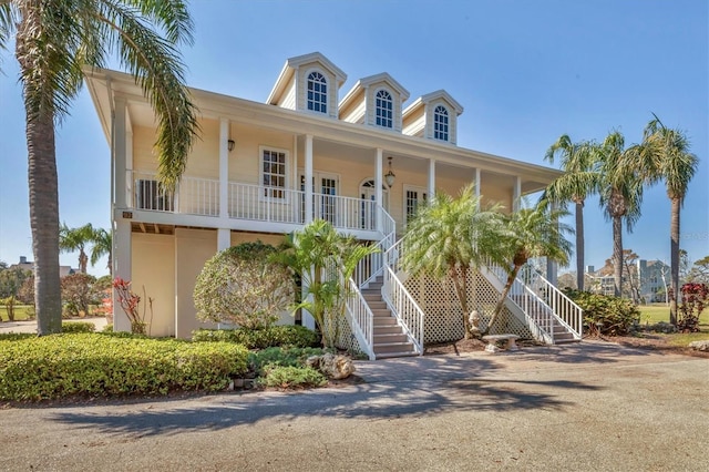 coastal inspired home featuring a porch and stairway