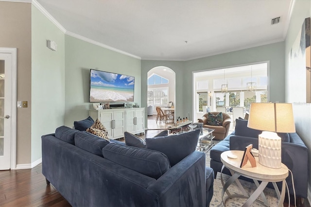 living area featuring dark wood-type flooring, visible vents, crown molding, and baseboards