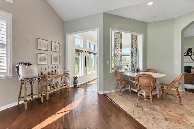 dining area featuring arched walkways, recessed lighting, wood finished floors, and baseboards