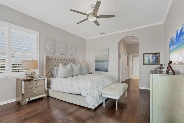 bedroom with arched walkways, dark wood-style flooring, and baseboards