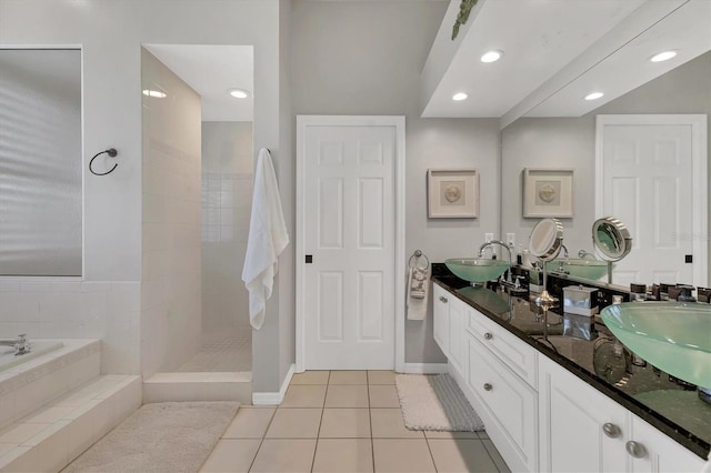 bathroom with a garden tub, a walk in shower, a sink, and tile patterned floors