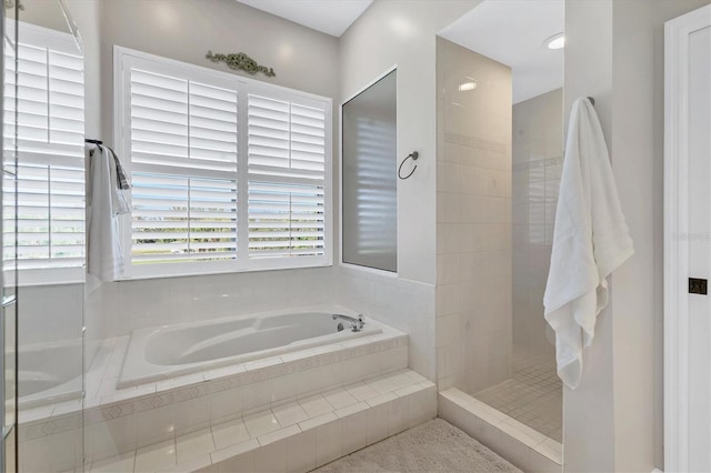 bathroom with a wealth of natural light, a garden tub, and walk in shower