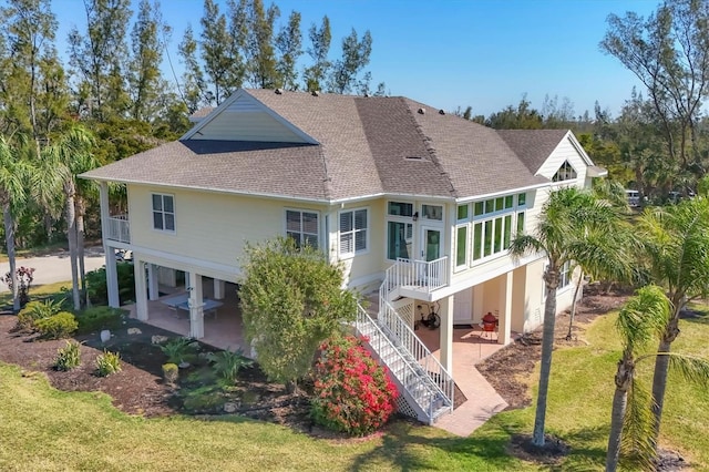 back of house with a patio area, a shingled roof, stairway, and a yard