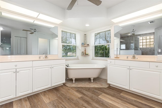 1730 Hudson St, Englewood, FL 34223 - full bath with ceiling fan, two vanities, a freestanding tub, a tile shower, and wood finished floors