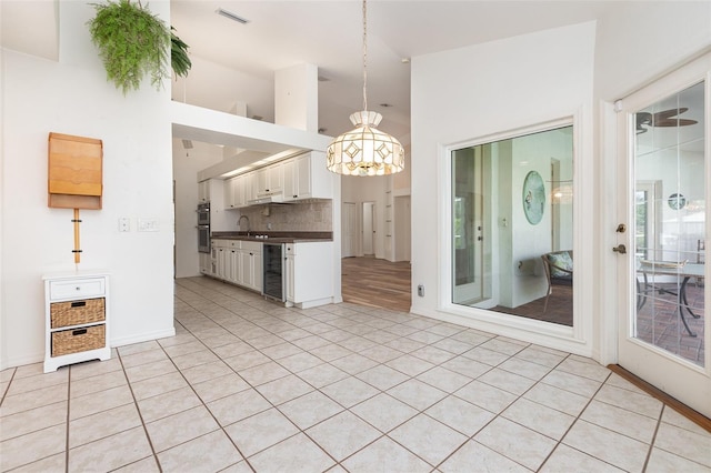 1730 Hudson St, Englewood, FL 34223 - kitchen with a chandelier, dark countertops, pendant lighting, double oven, and white cabinets
