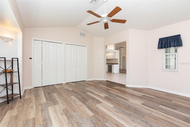 1730 Hudson St, Englewood, FL 34223 - unfurnished bedroom featuring multiple closets, light wood-style floors, vaulted ceiling, baseboards, and ceiling fan