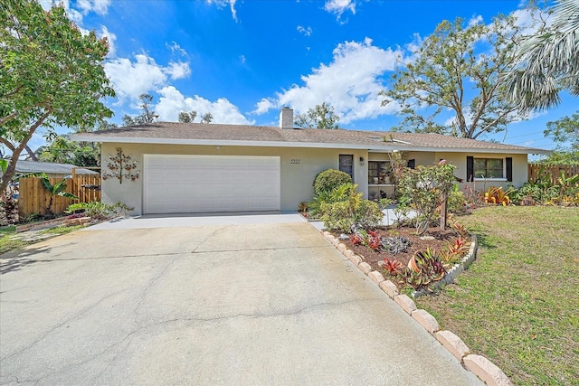 single story home featuring driveway, an attached garage, fence, and stucco siding