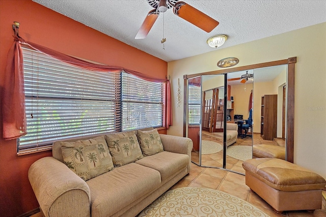 living area featuring a textured ceiling, vaulted ceiling, a ceiling fan, and tile patterned floors