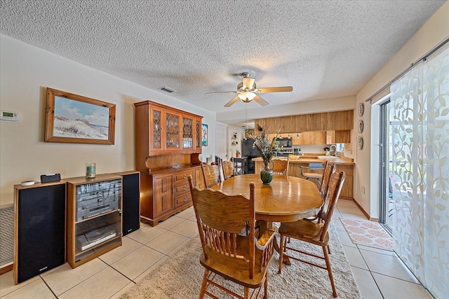 dining room featuring a ceiling fan, visible vents, a textured ceiling, and light tile patterned floors