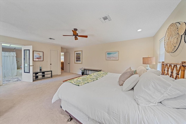 bedroom with light carpet, ceiling fan, visible vents, and a textured ceiling