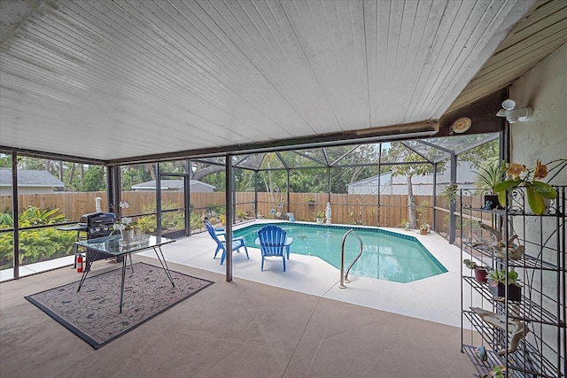 view of swimming pool featuring glass enclosure, a patio area, a fenced backyard, and a fenced in pool