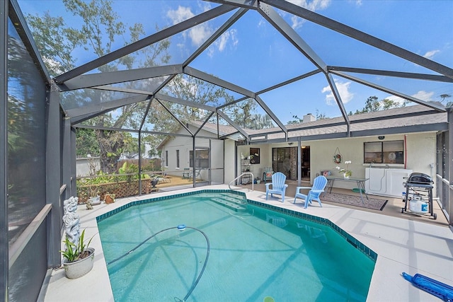 pool with glass enclosure and a patio