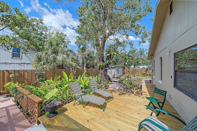 deck featuring an outbuilding, a fenced backyard, and a storage unit