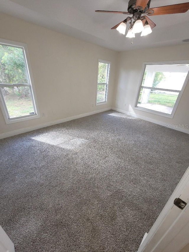 unfurnished room with carpet floors, ceiling fan, and baseboards