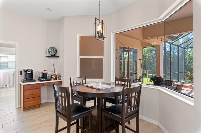 dining space featuring a sunroom and baseboards