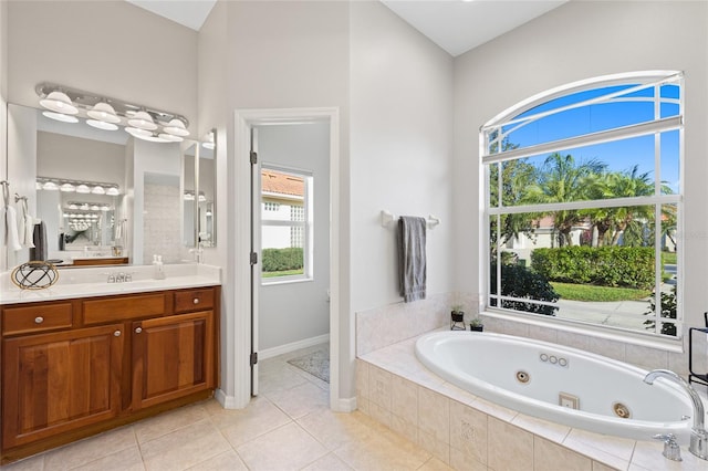 bathroom with a jetted tub, vanity, and tile patterned floors