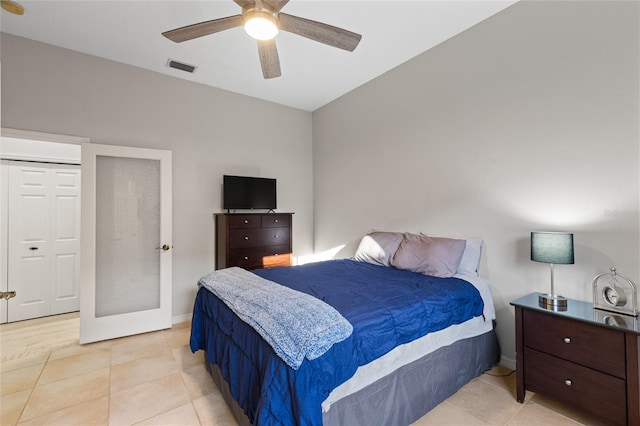 bedroom featuring a ceiling fan, visible vents, baseboards, and light tile patterned floors