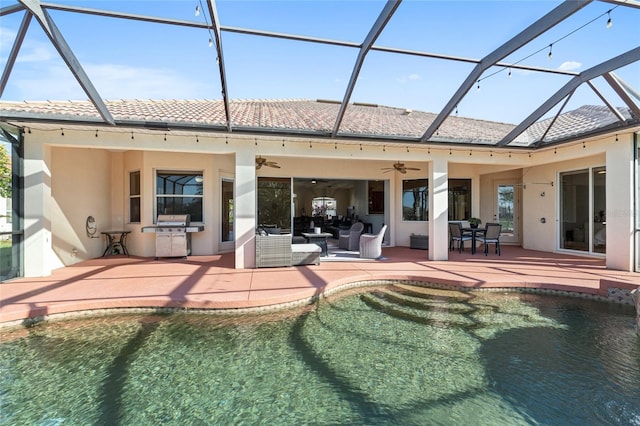 back of house with a patio area, glass enclosure, exterior kitchen, and stucco siding