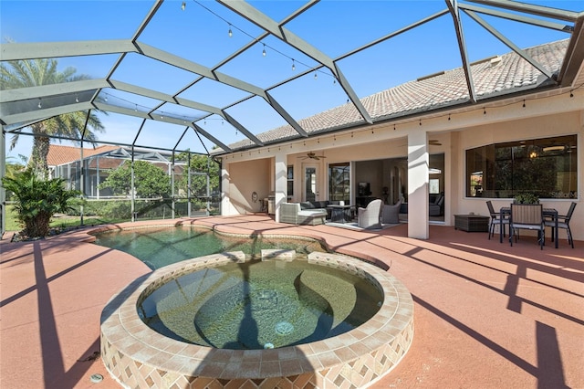 view of swimming pool with glass enclosure, ceiling fan, a patio area, a pool with connected hot tub, and outdoor lounge area