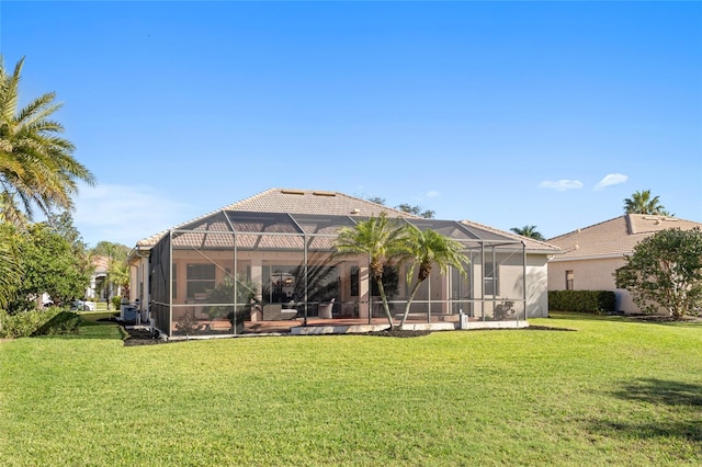 rear view of property featuring a lanai, stucco siding, a tile roof, and a yard