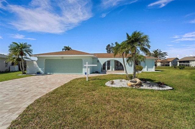 ranch-style home featuring a front yard, decorative driveway, an attached garage, and stucco siding