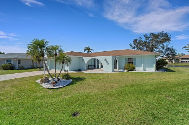 ranch-style house with driveway, a garage, a front lawn, and stucco siding