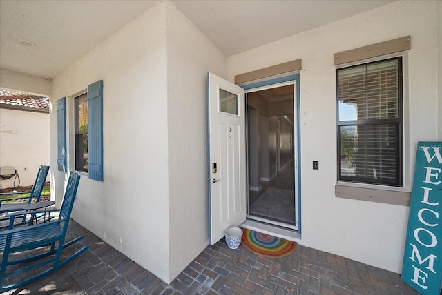 entrance to property featuring stucco siding