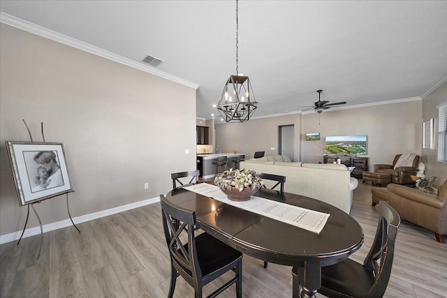 dining area featuring light wood-type flooring, baseboards, visible vents, and crown molding