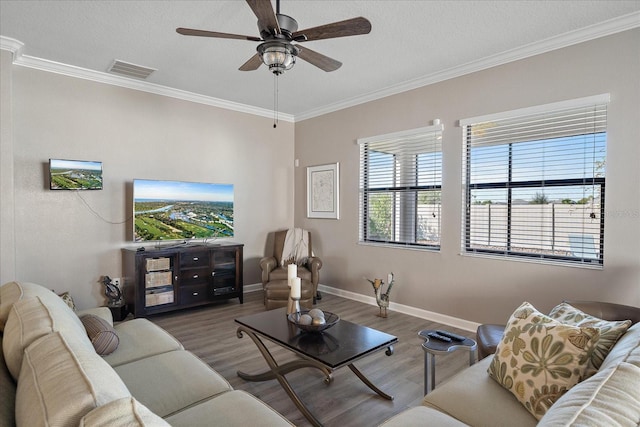 living area with visible vents, crown molding, and wood finished floors